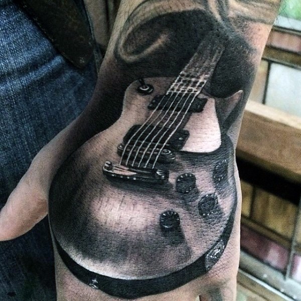 Real photo like black and white little guitar tattoo on wrist
