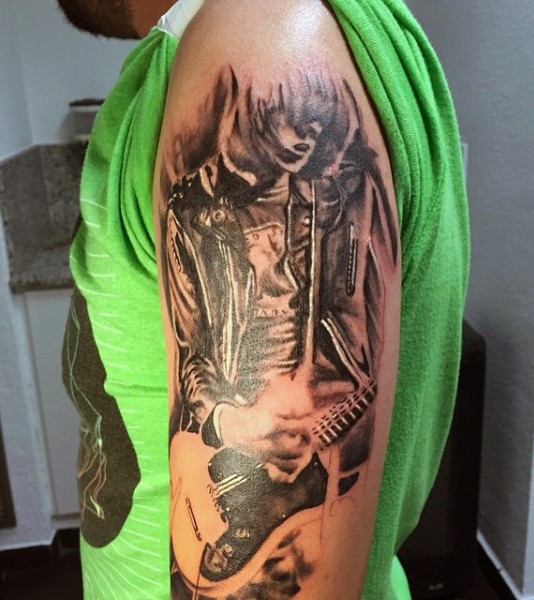 Tatuaje en el brazo, músico adorable que toca la guitarra