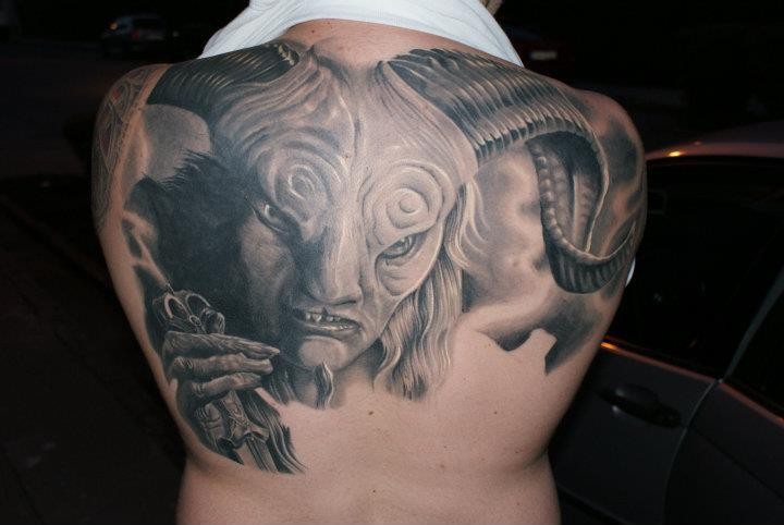 Tatuaje en la espalda alta,  cara de diablo aterrador impresionante