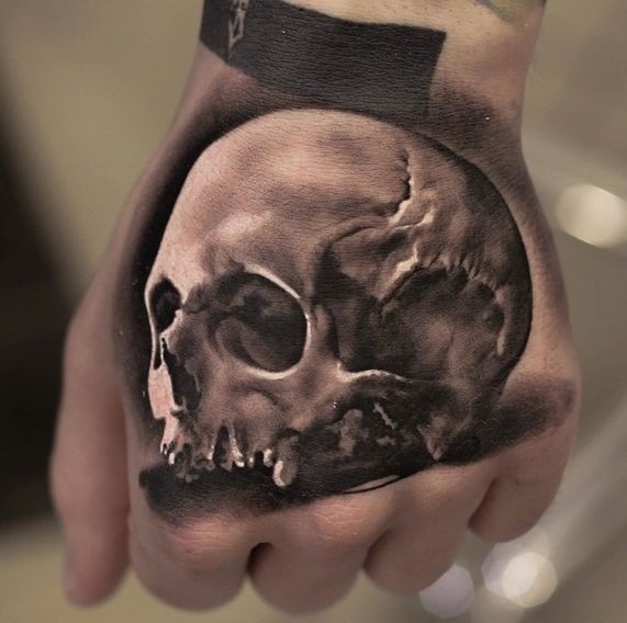 Farbiges Hand Tattoo vom beschädigten menschlichen Schädel