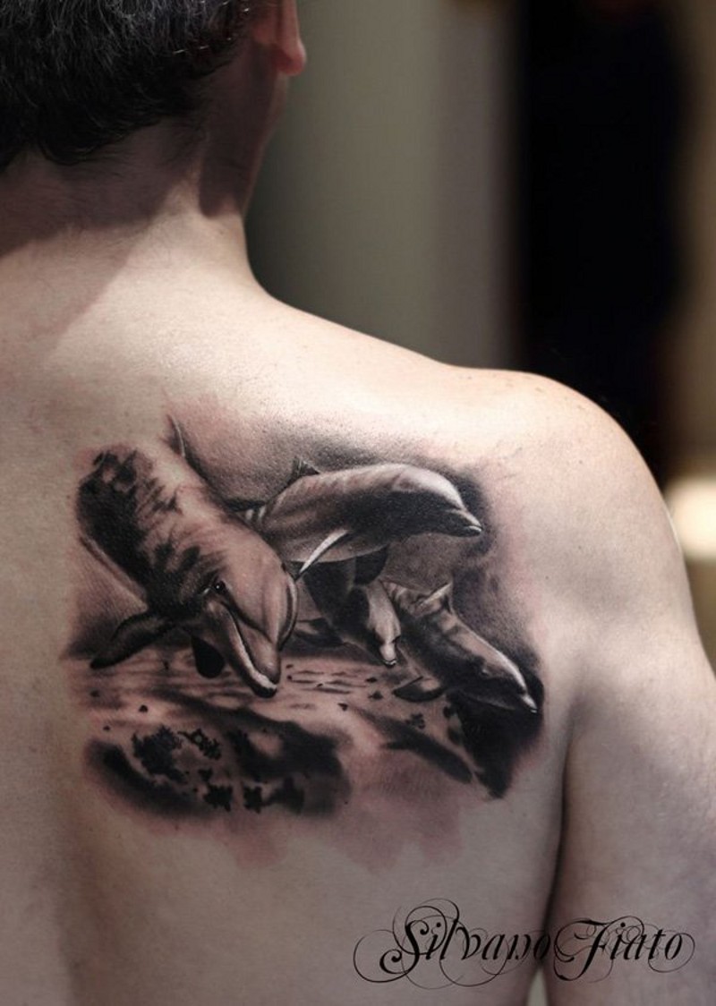 Real photo like little black and white dolphins tattoo on shoulder