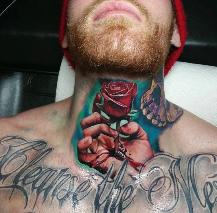 Real photo like natural colored bleeding hand with rose tattoo on neck stylized with skull