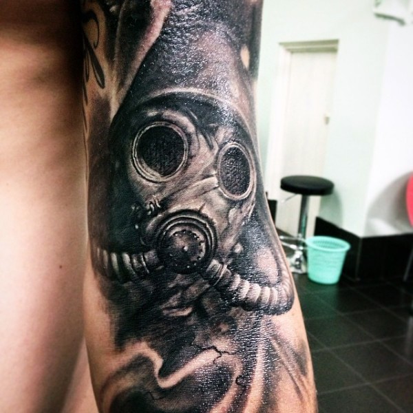 Realism style amazing looking black and white arm tattoo of soldier in gas mask