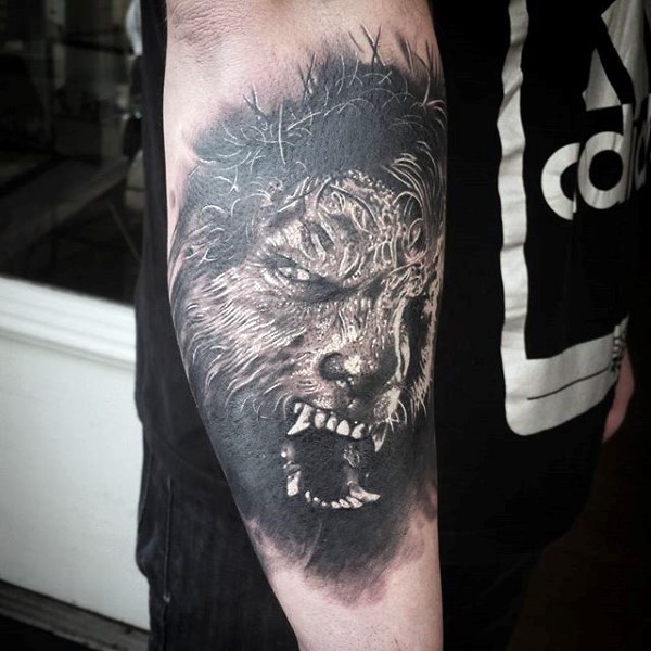 Realism style black and white werewolf face tattoo on forearm