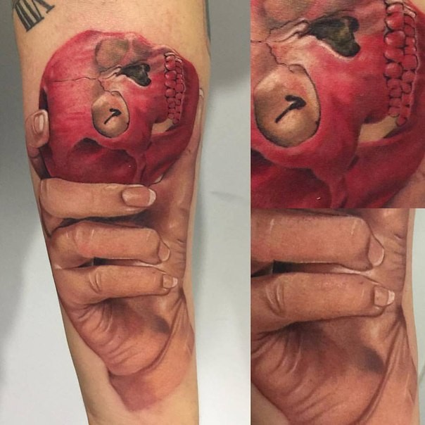 Realism style colored arm tattoo of human hand with skull