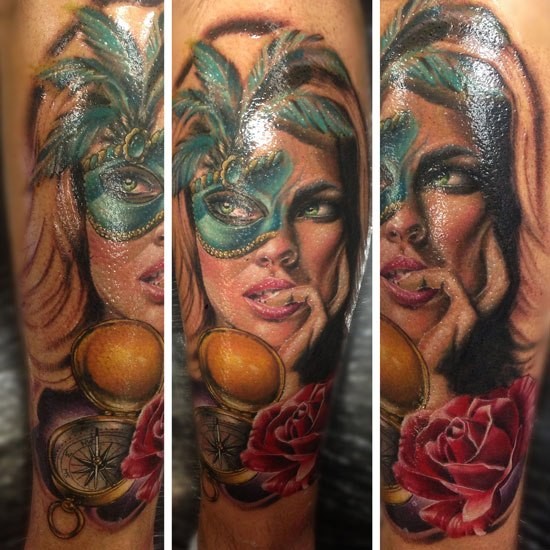 Realism style colored arm tattoo of woman with mask and compass