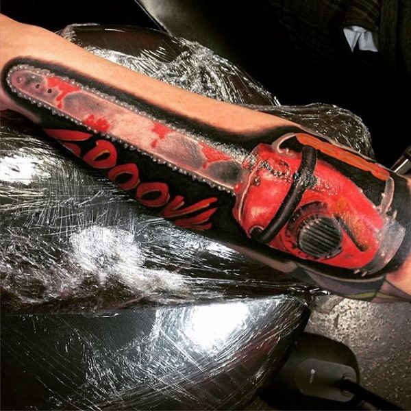 Realism style colored forearm tattoo of bloody saw and lettering
