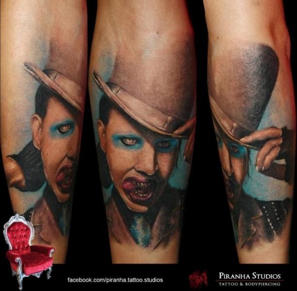 Realism style colored forearm tattoo of Merlin Manson in hat