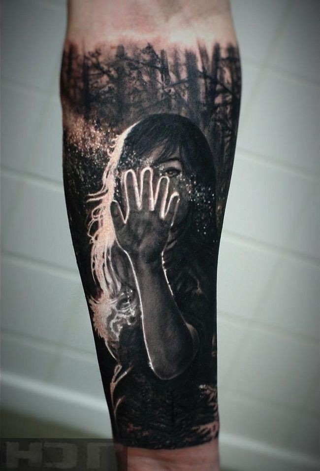 Realism style colored forearm tattoo of woman with sun light in dark forest