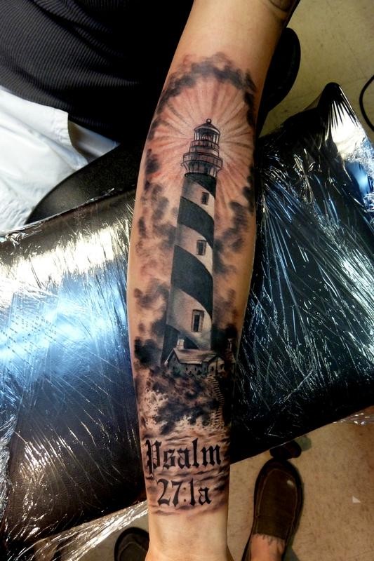 Realism style colored forearm tattoo of big lighthouse and lettering
