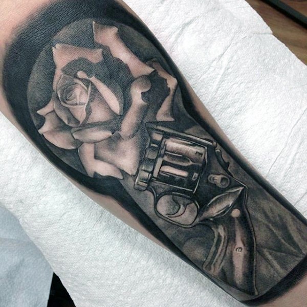 Realism style colored forearm tattoo of old revolver and big rose