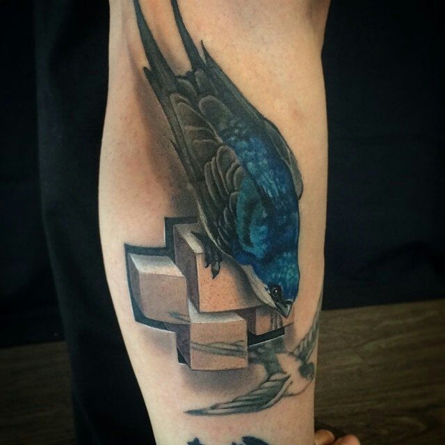 Realism style colored leg tattoo of beautiful bird with stone cross