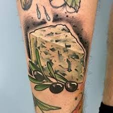 Realism style colored leg tattoo of cheese and olives