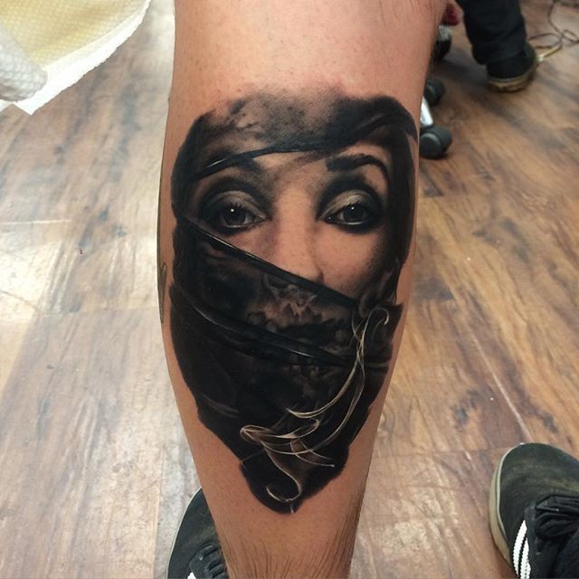 Realism style colored leg tattoo of woman in mask