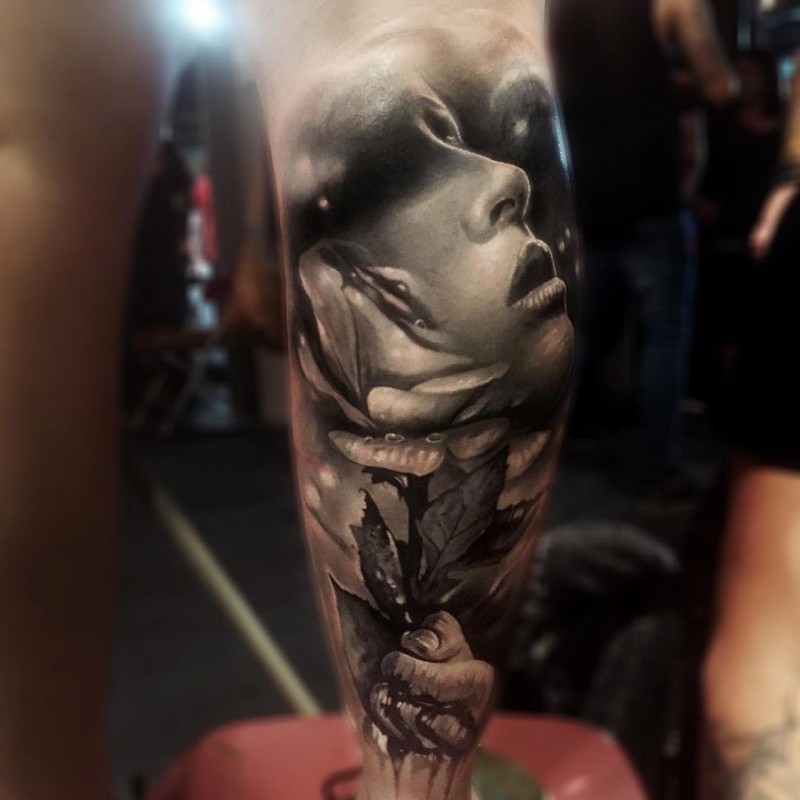 Realism style colored leg tattoo of woman face with rose