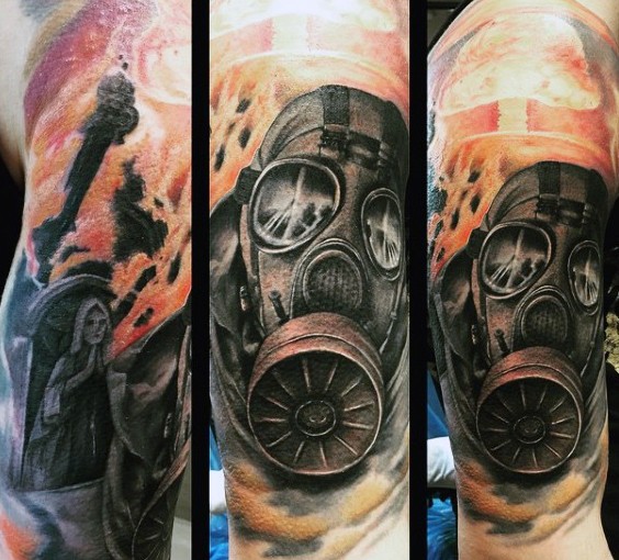 Realism style colored nuclear blast tattoo on shoulder stylized with man in gas mask