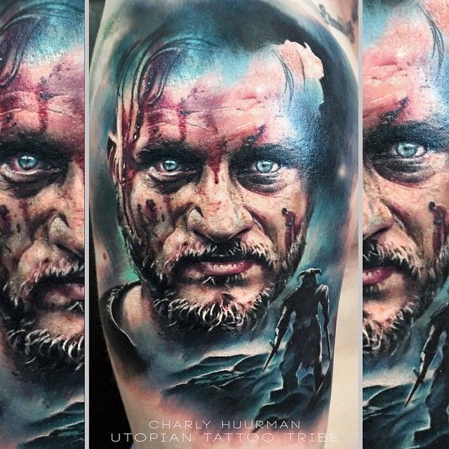 Realism style colored shoulder tattoo of bloody Viking TV serial hero portrait