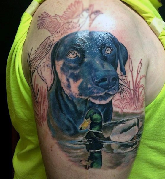 Realism style colored shoulder tattoo of hunters dog with ducks
