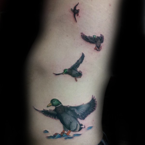 Realism style colored side tattoo of flying ducks