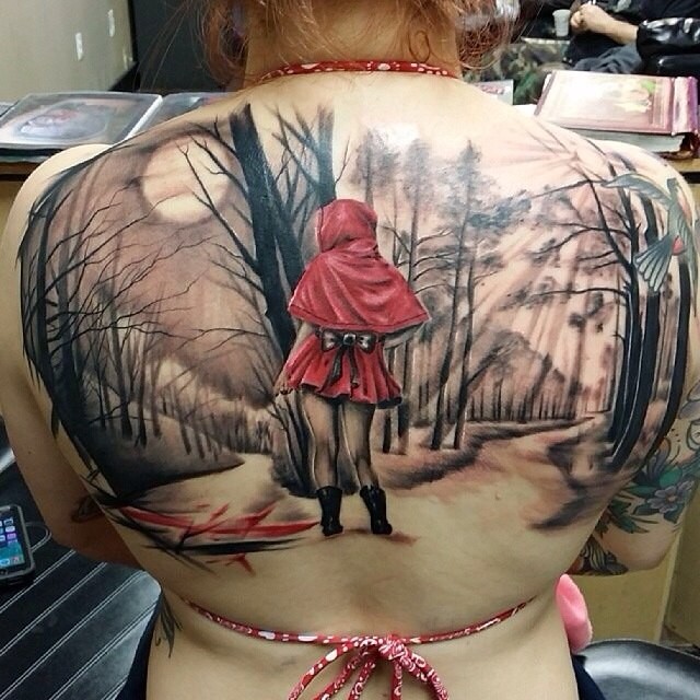 Realism style colored upper back tattoo of little girl in dark forest