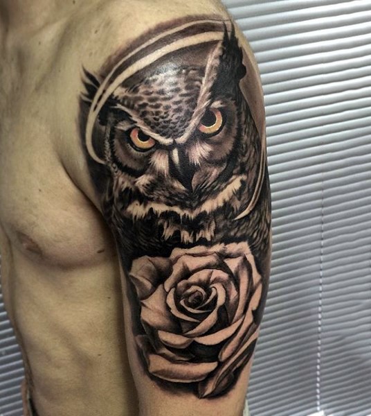 Realism style cool looking shoulder tattoo of big owl with rose flower