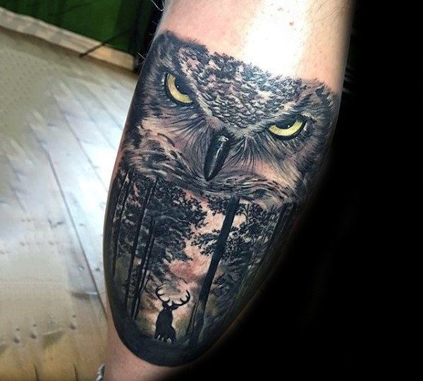 Realism style detailed and colored arm tattoo of owl face and deer in forest