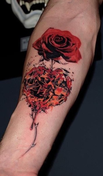 Realism style red colored rose tattoo on forearm with heart