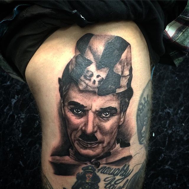 Realism style very detailed tattoo of cool Charlie Chaplin with lettering