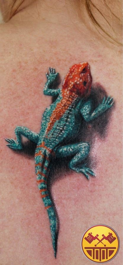 Realistic agama lizard tattoo on back for girls