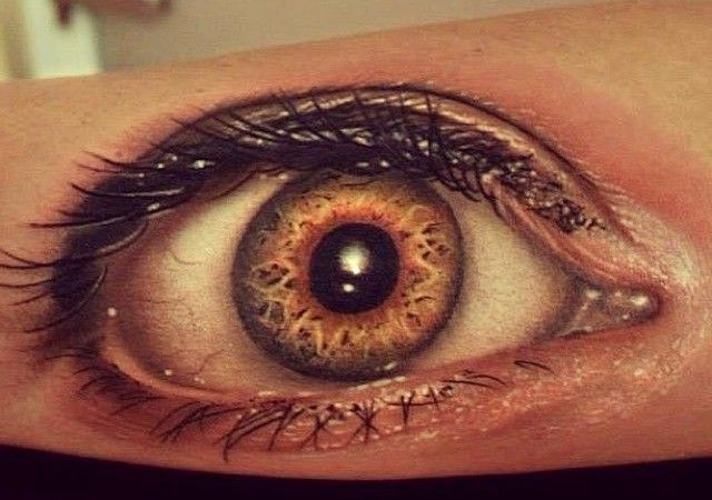 Tatuaje en el brazo de un ojo humano real.