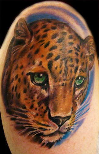 Tatuaje en el brazo, leopardo con ojos verdes