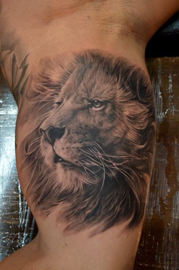 Realistic lion head tattoo on biceps