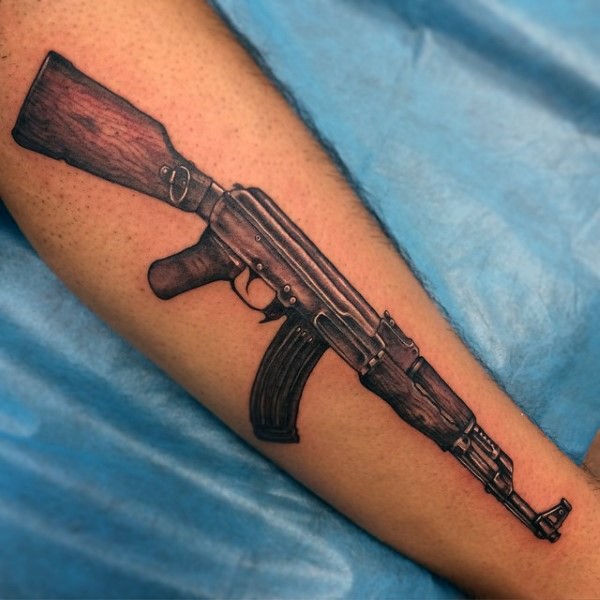 Realistic looking arm tattoo of AK 47 rifle