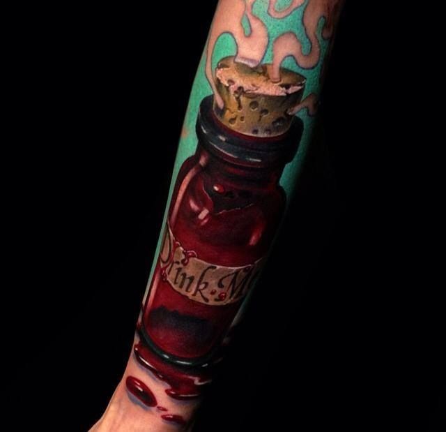 Realistic looking arm tattoo of little bottle with lettering