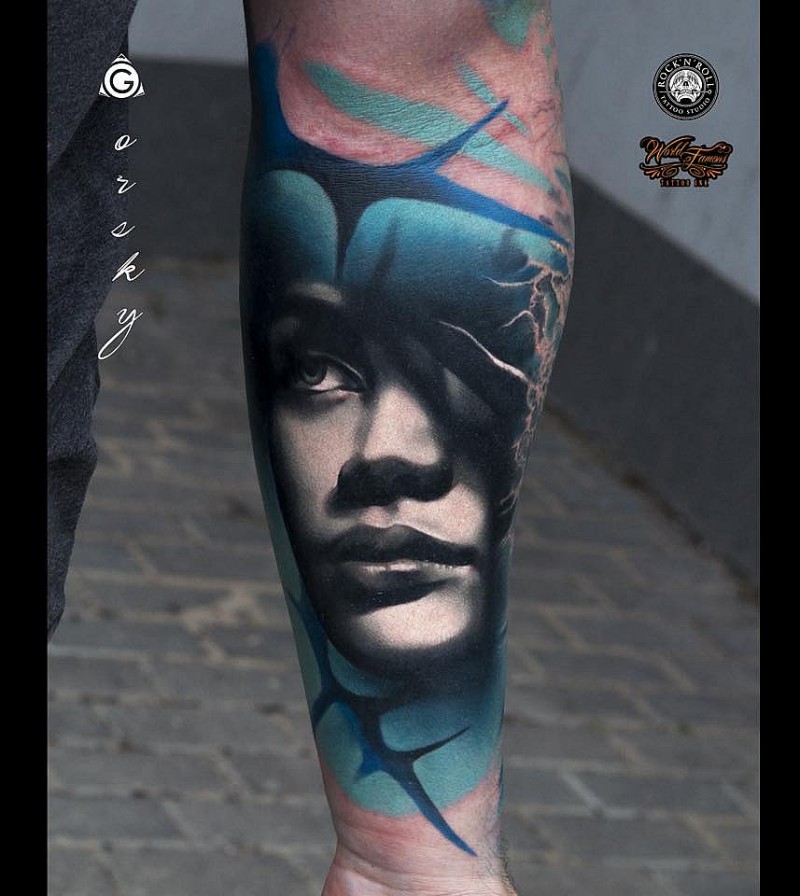 Realistic looking colored arm tattoo of woman face