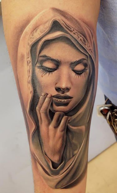 Realistic looking colored arm tattoo of sad woman face