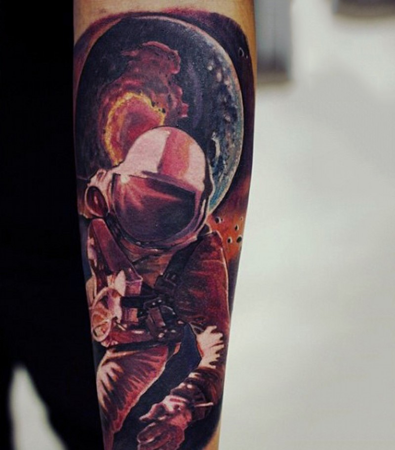 Realistic looking colored astronaut in open space tattoo on arm