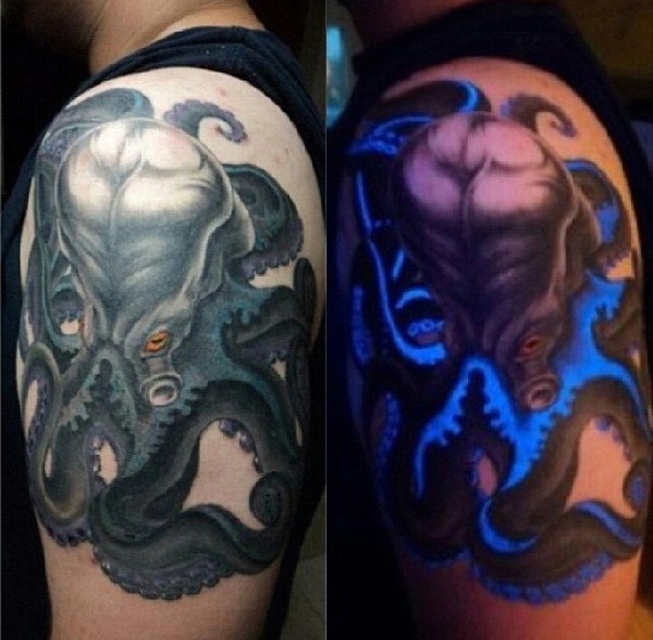Realistic looking colored big glowing octopus tattoo on upper arm area