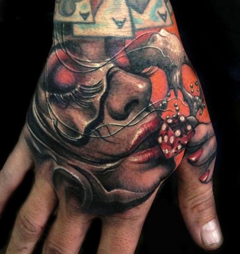 Realistic looking colored colored woman portrait tattoo on hand with red dice
