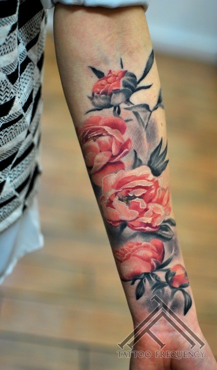 Realistic looking colored forearm tattoo of various flowers