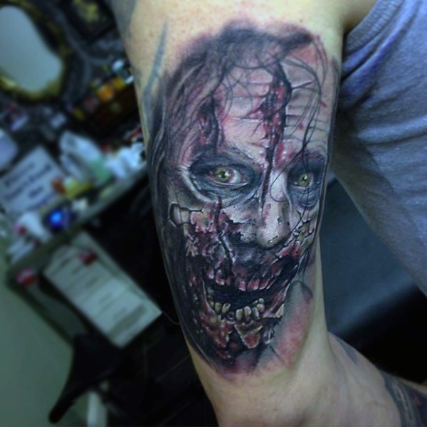 Realistisch aussehendes farbiges im Horror Stil Arm Tattoo von Zombies Gesicht