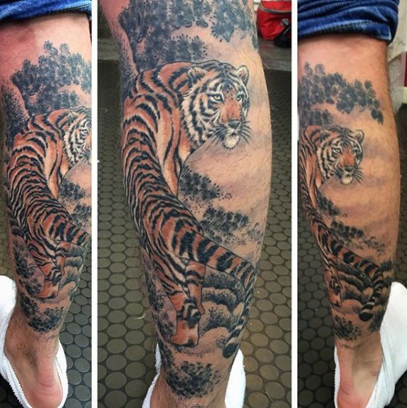 Realistic looking colored leg tattoo of tiger in jungle