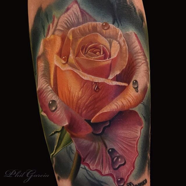 Realistic looking colored rose tattoo on arm