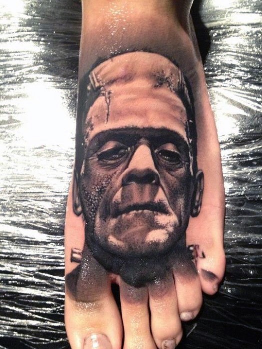 Realistic looking detailed black and white Frankenstein monster face tattoo on foot