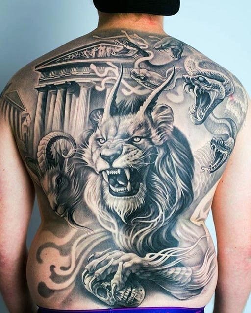 Tatuagem realística toda pintada de leão demoníaco com cobras e cabra