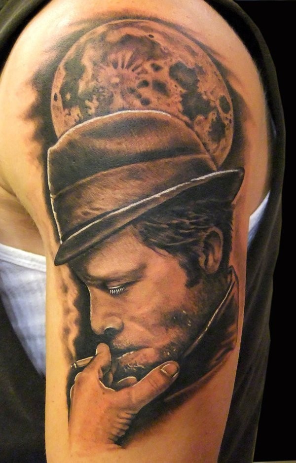 Tatuaje en el brazo, hombre en sombrero que fuma y luna llena
