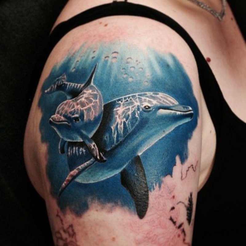 realistico foto colorato acqua marina delfini tatuaggio su spalla