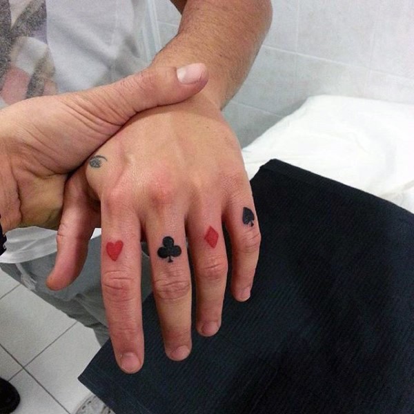 Red and black card suits small tattoo on fingers