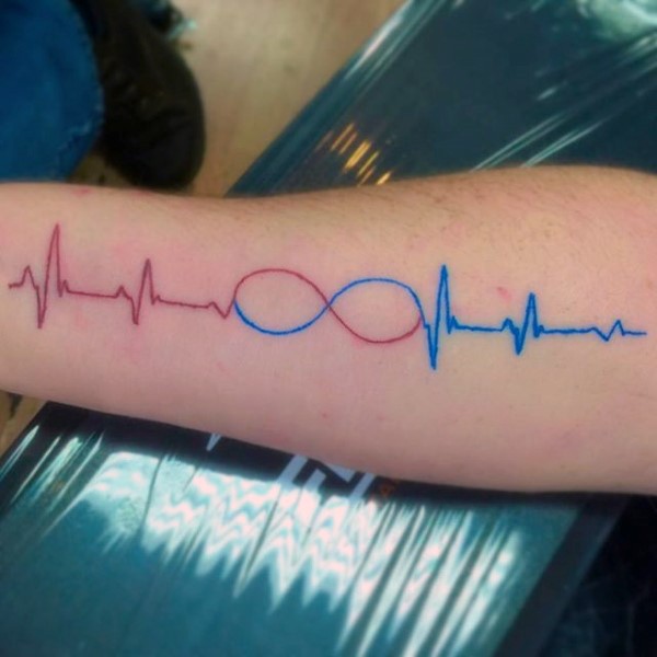 Rotes und blaues Herz-Rhythmus mit Unendlichkeitssymbol Tattoo am Arm