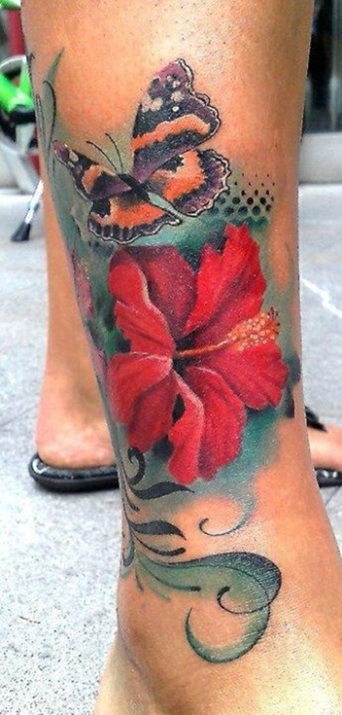 Red hibiscus flower with butterfly tattoo on leg